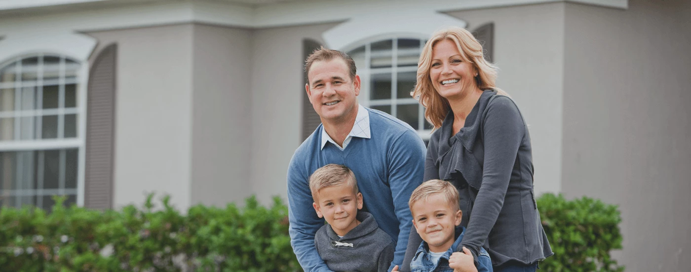 family-standing-in-front-of-house